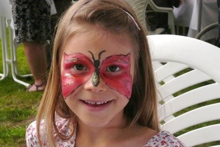 Kinderschminken auf dem Sommerfest der Klinik für Palliativmedizin: Mädchen mit Schmetterlingsbemalung