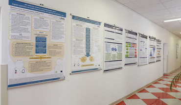 Wand mit Plakaten zu Forschungsthemen der Klinik für Palliativmedizin