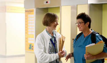 2 Mitarbeiterinnen der Palliativmedizin auf dem Flur der Universitätsklinik Göttingen im Gespräch